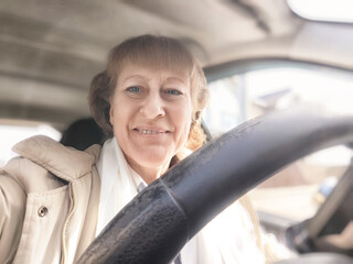 Middle-aged woman takes a cheerful selfie while driving during an exciting road trip adventure