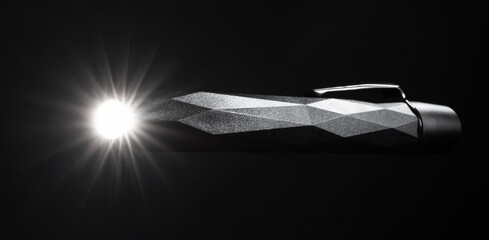 Bright light coming from a penlight flashlight's LED on a black background
