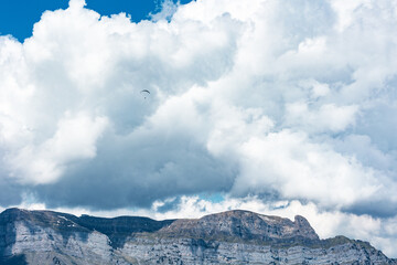 Paraglider, clouds, mountain range, flying, Switzerland, Swiss Alps, Canton St. Gallen.  Extreme...
