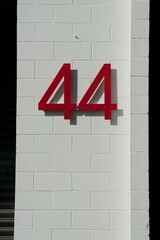 Red Number 44 Painted on White Brick Wall