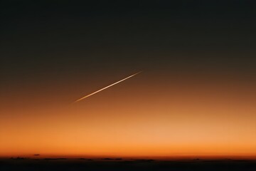 Streak of contrail across sunset sky with gradient twilight horizon