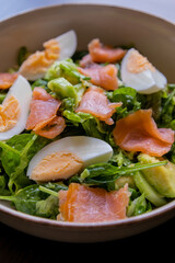 delicious and healthy salad with smoked salmon, boiled egg, greens, and fresh vegetables