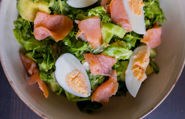 delicious and healthy salad with smoked salmon, boiled egg, greens, and fresh vegetables