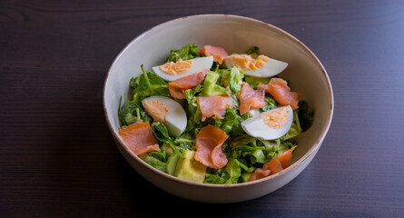 delicious and healthy salad with smoked salmon, boiled egg, greens, and fresh vegetables