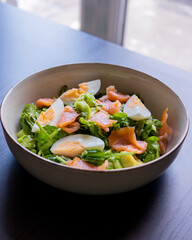 delicious and healthy salad with smoked salmon, boiled egg, greens, and fresh vegetables