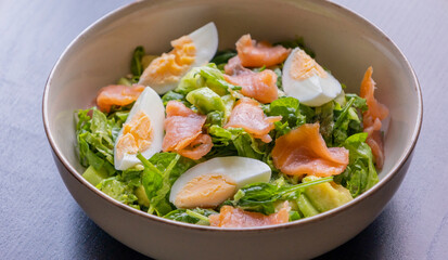 delicious and healthy salad with smoked salmon, boiled egg, greens, and fresh vegetables