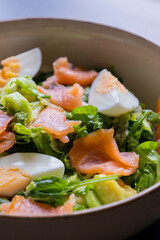 delicious and healthy salad with smoked salmon, boiled egg, greens, and fresh vegetables