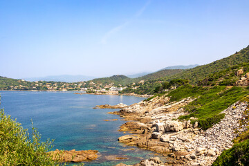 Rocky coastline with turquoise sea and green hills, Corsica, 13 June 2025