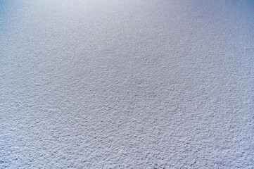 Snow-covered ground creates a serene winter landscape during a bright sunny day in a remote area