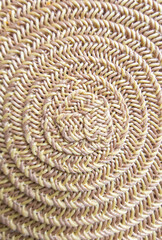 Handwoven natural fiber mat showcasing intricate spiraled design, perfect for home decor in cozy living spaces or outdoor settings