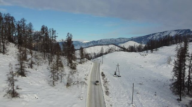 Drone footage of snowy mountains, valleys, and forests in Ust-Koksa, Altai Republic, Russia, under clear skies, showing the remote region&rsquo;s beauty during winter.