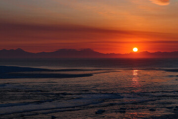 Obraz premium Fiery Red Sunset Over a Frozen Arctic Sea