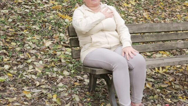 Middle aged woman holding chest in pain, sudden cardiac symptom, heart discomfort, possible rare cardiac condition, health risk
