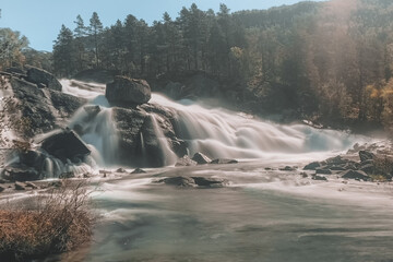 long exposure waterfall in norway with trees in background