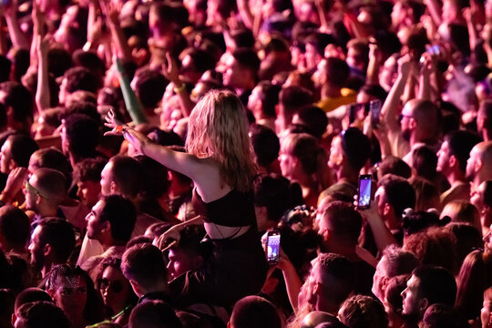 Young woman crowd surfing and dancing at music festival