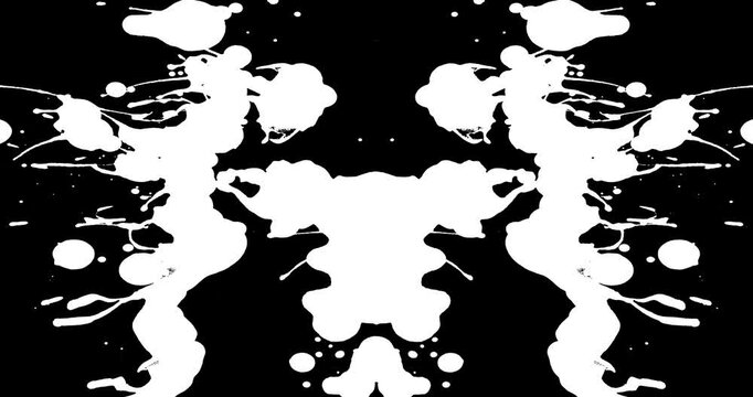 Normal speed shot of white paint splatters on a black background which is mirrored to create a Rorschach image.