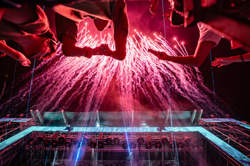 Spectators watching fireworks exploding over concert stage at night