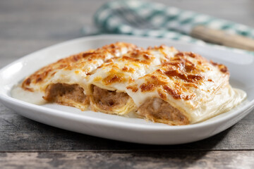 Baked meat cannelloni with Cheese and Béchamel Sauce on wooden table