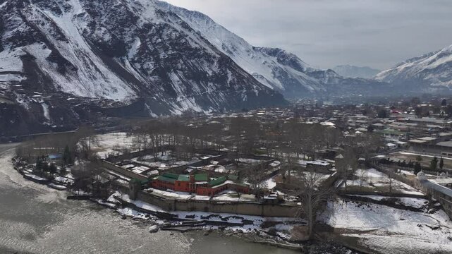 Aerial view in Winter of a historical Fort in Chitral, Pakistan. Bright building along the riverbank in Kalash Valley.