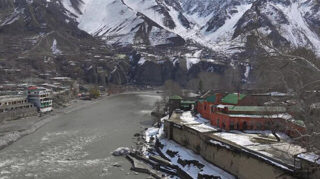 Aerial view in Winter of a historical Fort in Chitral, Pakistan. Bright building along the riverbank in Kalash Valley.