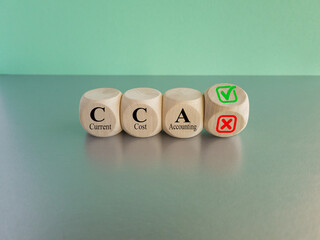 Turned wooden cube with red reject X and green confirm tick as change concept of CCA. Word CCA -...