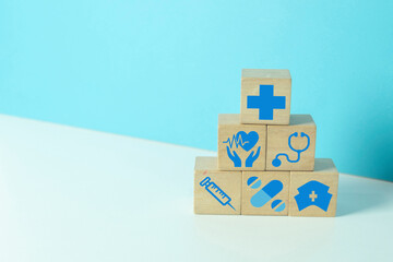 Healthcare and medical concept. A pyramid of wooden blocks with icons including a...