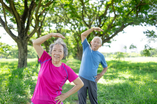 Happy asian senior couple exercising in the park.
