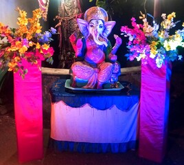 Lord Ganesha Idol with Colorful Flowers and Lights – Hindu God Ganpati Decorated for Festival or Puja Celebration