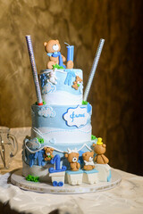 A three-tier blue and white birthday cake decorated with fondant, figurines in the shape of bears and a bunny with the male name Philip written in Cyrillic.