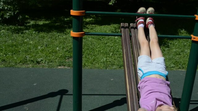 Little girl is doing sports on simulator