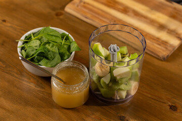 Ingredients for a healthy green smoothie on a wooden table