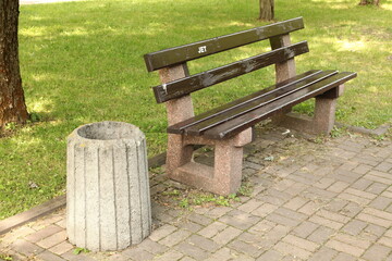 Ukraine. Kyiv. A bench in a summer park. There are many trees and bushes around.