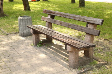 Ukraine. Kyiv. A bench in a summer park. There are many trees and bushes around.