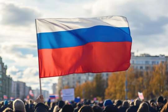 Russian flag waves at a political rally in the city under a cloudy sky