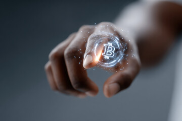 Businessman touching hologram of bitcoin cryptocurrency sign in futuristic digital sphere