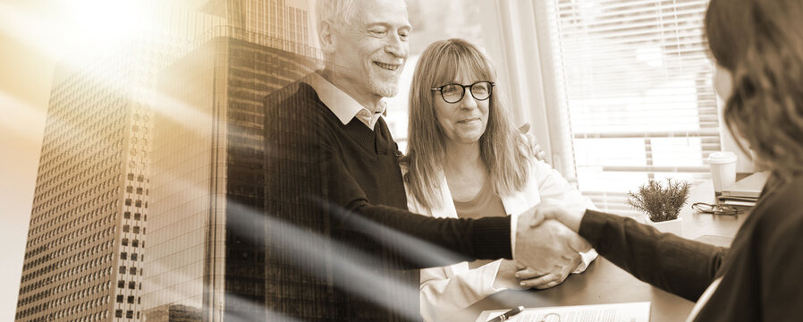 Female realtor giving handshake to happy senior couple after successful agreement; multiple exposure
