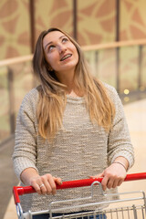 Caucasian woman with braces pushing shopping cart. 
