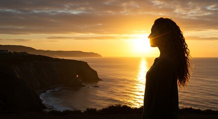 Silhouette of a Woman Watching the Sunset Over the Ocean Waves