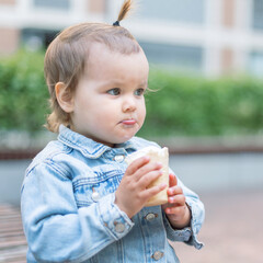 A happy fun cute child  eats ice cream on a hot day in park. Ice cream in a waffle cone.