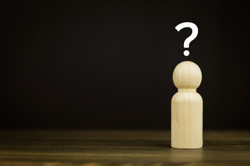 Wooden doll and question mark symbol with copy space. Concept of asking and answering questions,...