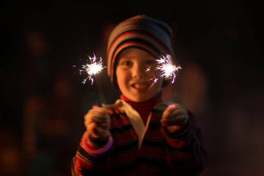 Little boy waving sparklers on a bonfire night