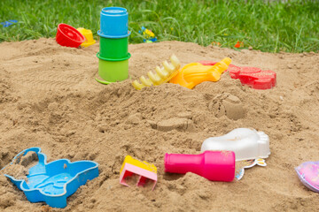 Empty children's sandbox with bright toys. Side view. Children's recreation in summer. Children's playground.