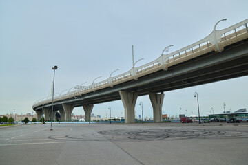 A Modern Elevated Bridge Structure Positioned Distinctively in an Urban Landscape Setting