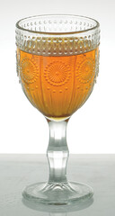 Elegant Glassware: Ornate Wine Goblet with Amber Liquid