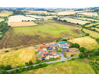 Aerial view of a once brownfield site, now a small and exclusive housing development seen in rural Essex, UK during a hot summer.
