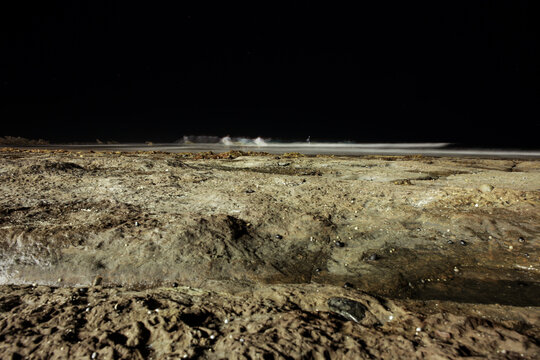 Night surfing at Mollymook with blurred surfer detail in the distance