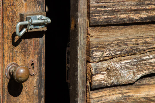 Old wooden door with a new bolt on it