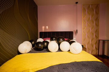 Balloons with graduation greeting text on a bed