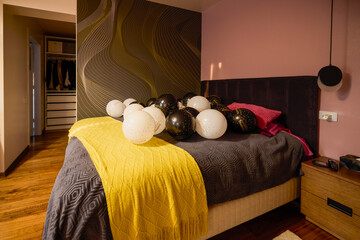 Balloons with graduation greeting text on a bed