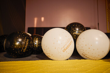 Balloons with graduation greeting text on a bed
